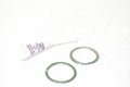 Two gaskets and a small tube on a white background