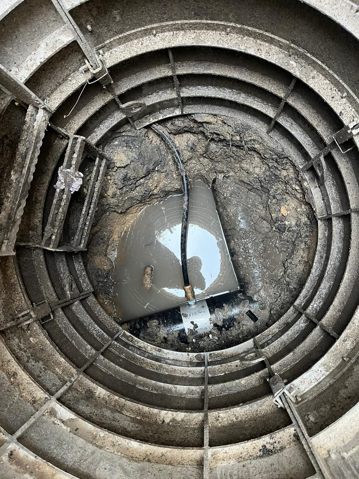 Sewershop EasyDig modular circular trench cage installed in a muddy excavation site for underground utility repair.