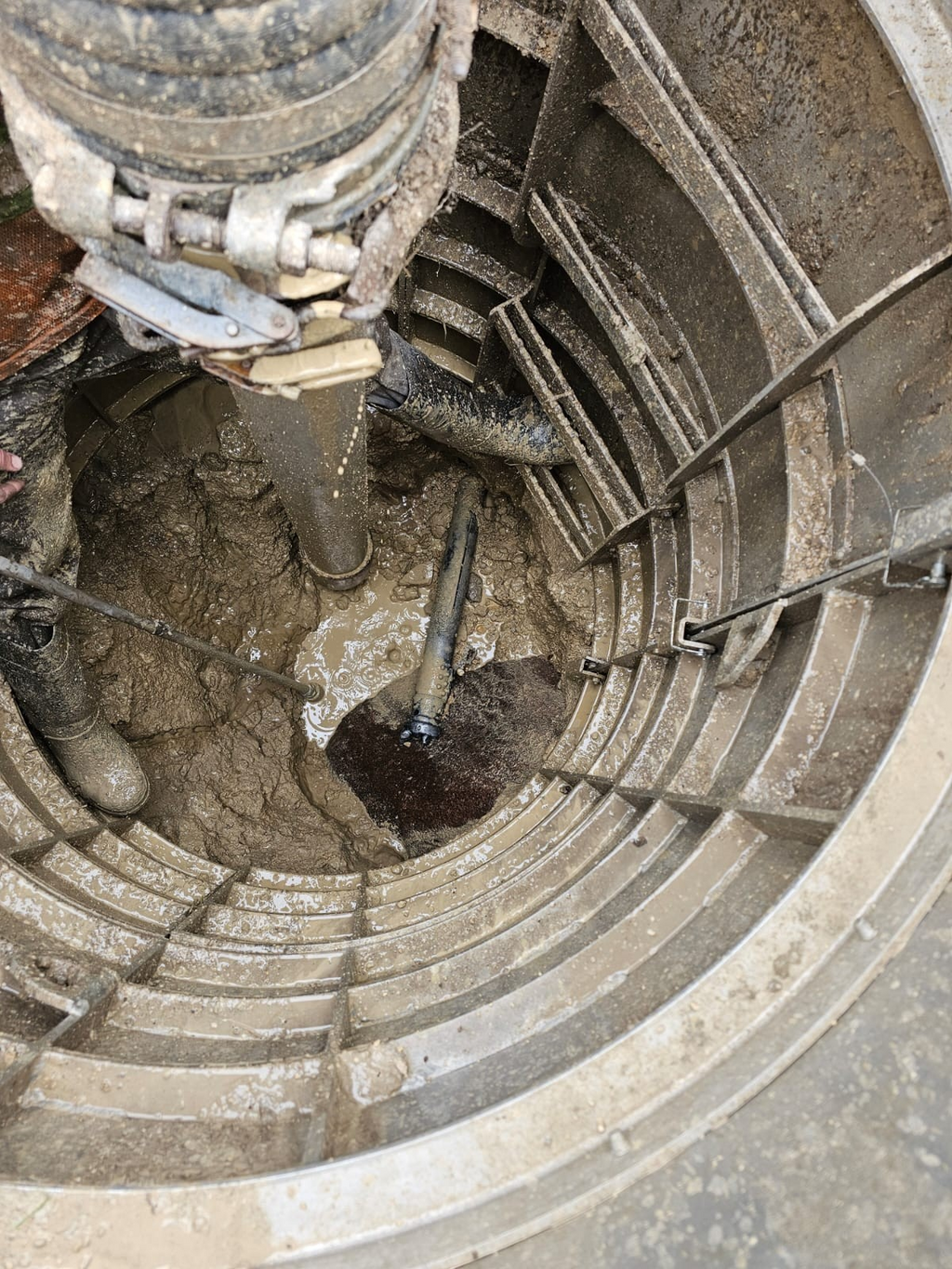 Sewershop EasyDig modular circular trench cage installed in a muddy hydrovac excavation site for utility repair.