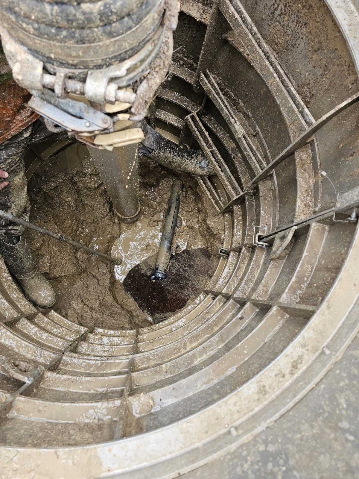 Sewershop EasyDig modular circular trench cage installed in a muddy hydrovac excavation site for utility repair.